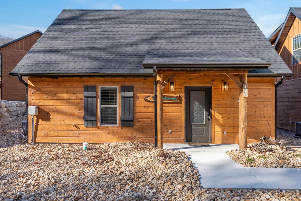 A welcoming wooden facade and front door are framed by a landscaped pathway. The home’s modern exterior hints at the freshness of a newly built property, inviting guests to step into a new experience.
